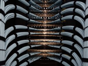Server rack with multiple servers and magnifying glass zooming in on a single server with a puzzle piece fitting into place