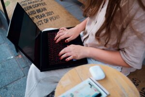 Person working remotely on laptop with cityscape in background showcasing flexible Windows VPS RDP