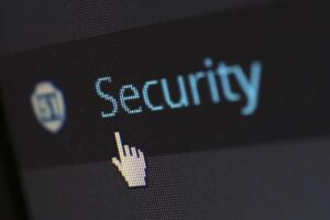 A digital shield protects a central server from incoming malicious network requests, illustrating the prevention of DDoS attacks by disabling WordPress XML-RPC trackbacks.